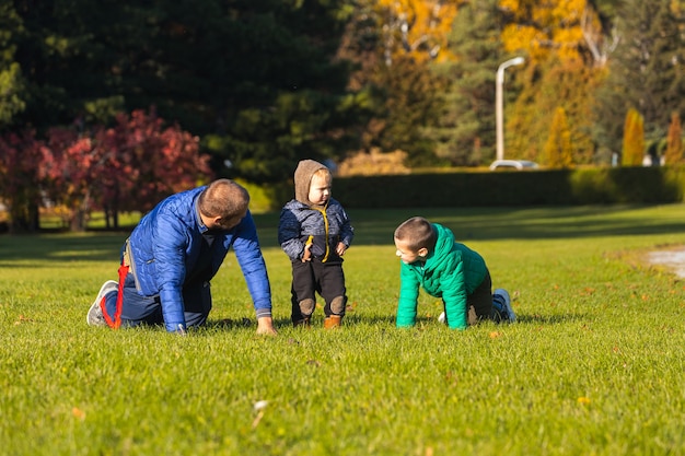 Junger Vater spielt mit Söhnen im Park