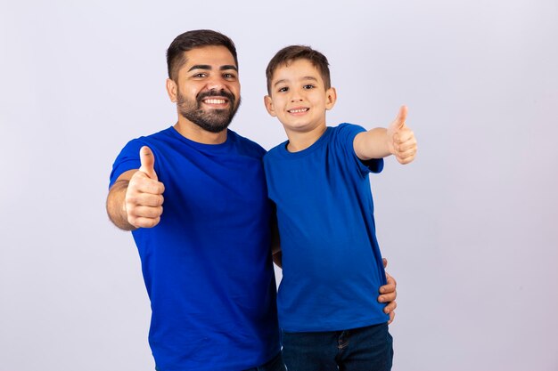 Junger Vater steht neben seinem Sohn mit erhobenem Daumen. Wir empfehlen den Vatertag