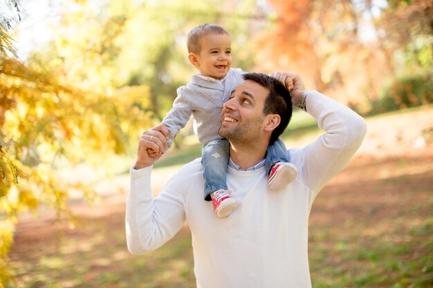 Junger Vater und Baby im Herbstpark