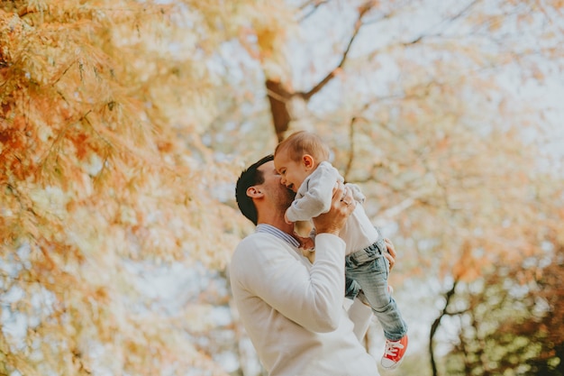 Junger Vater und Baby im Herbstpark