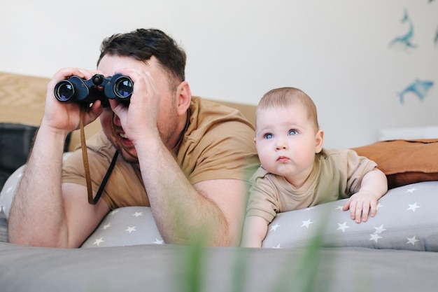 Junger Vater und kleines Kind posieren während der warmen Tageszeit positiv in der Natur