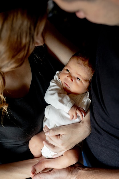 Junger Vater und Mutter halten ihren neugeborenen kleinen Sohn. Mama, Papa und Baby. Glückliches Familienkonzept. Speicherplatz kopieren.