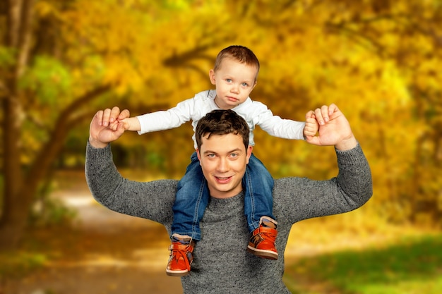 Junger Vater und sein lächelnder Sohn, die zusammen Zeit, Vatertagsfeier umarmt und genießt