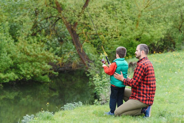 Junger Vater und sein Sohn angeln in der Natur