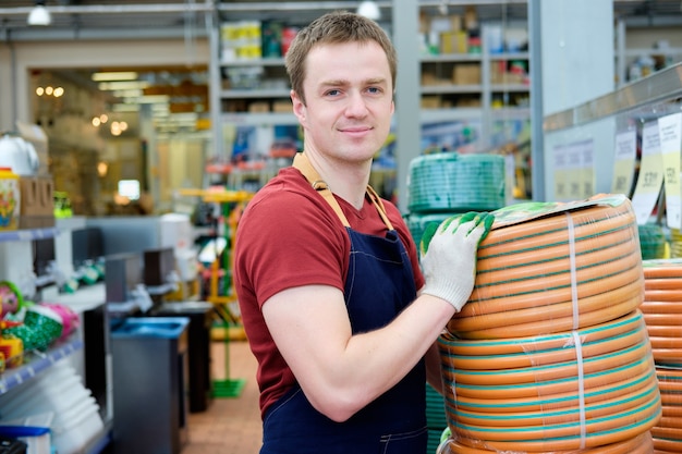 Junger Verkäufer im Pflanzenmarkt