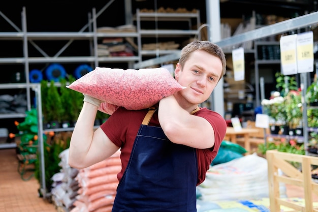 Junger Verkäufer im Pflanzenmarkt