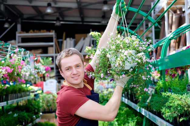 Junger Verkäufer im Pflanzenmarkt