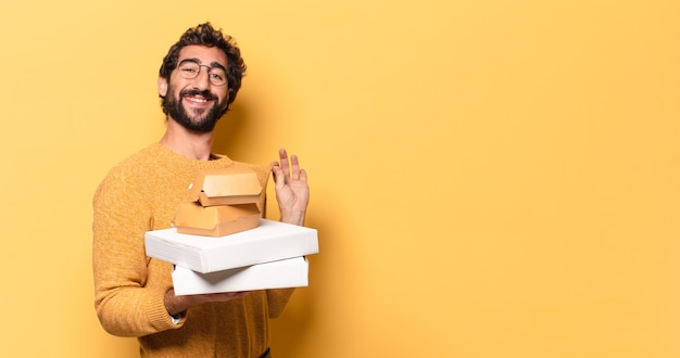 Foto junger verrückter bärtiger mann, der fastfood mit einem kopienraum wegnehmen