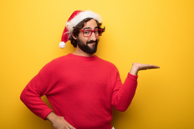 Junger verrückter bärtiger Mann, der rote Gläser und Weihnachtsmann-Hut trägt