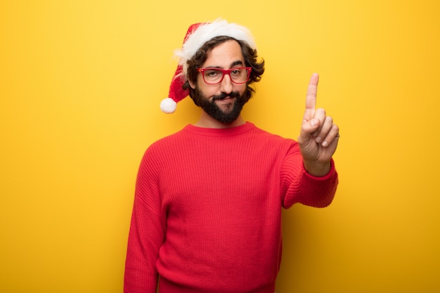 Junger verrückter bärtiger Mann, der rote Gläser und Weihnachtsmann-Hut trägt