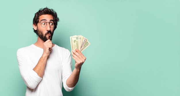Junger verrückter bärtiger Mann mit Dollarbanknoten