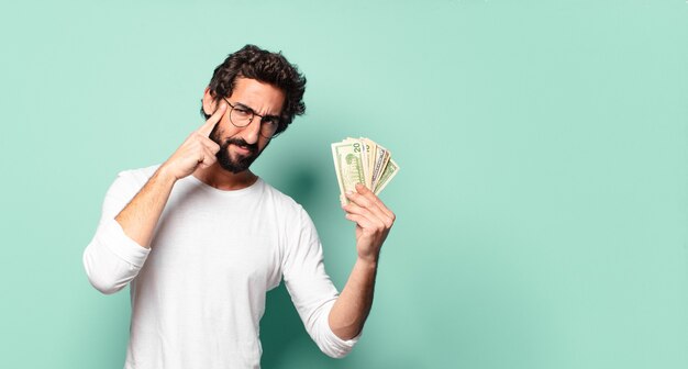 Junger verrückter bärtiger Mann mit Dollarbanknoten