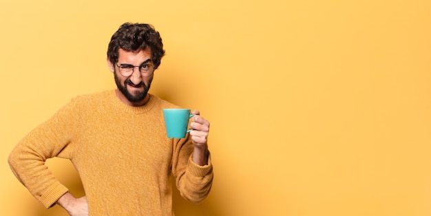 Junger verrückter bärtiger Mann mit einer Kaffeetasse