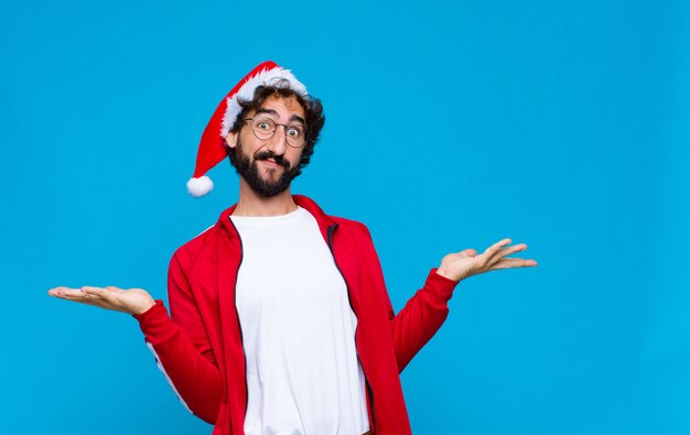 Junger verrückter bärtiger Mann mit Sankt-Hut. Weihnachtskonzept