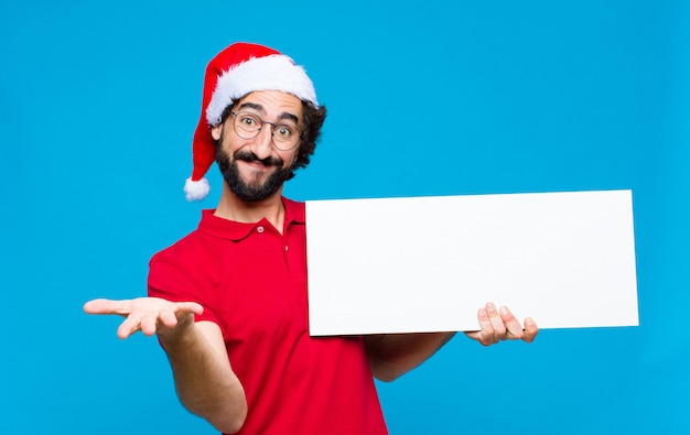 Junger verrückter bärtiger Mann mit Sankt-Hut. Weihnachtskonzept