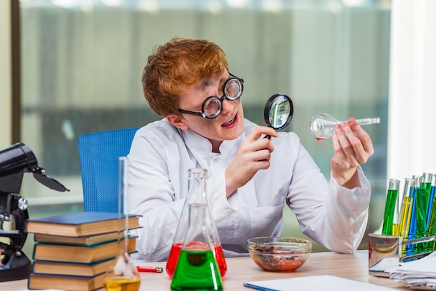 Foto junger verrückter chemiker, der im labor arbeitet