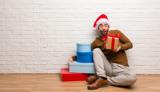 Junger verrückter Mann, der Weihnachten in seinem Haus feiert