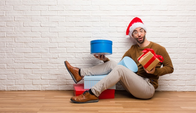 Junger verrückter Mann, der Weihnachten in seinem Haus feiert