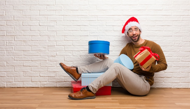 Junger verrückter Mann, der Weihnachten in seinem Haus feiert