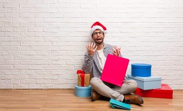 Junger verrückter Mann, der Weihnachten in seinem Haus feiert