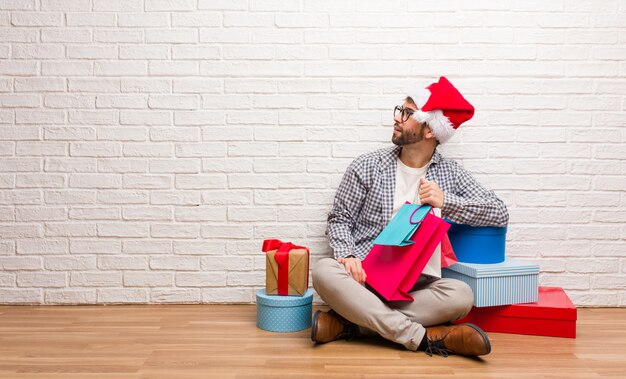 Junger verrückter Mann, der Weihnachten in seinem Haus feiert