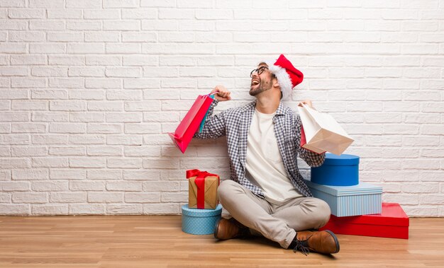 Junger verrückter Mann, der Weihnachten in seinem Haus feiert