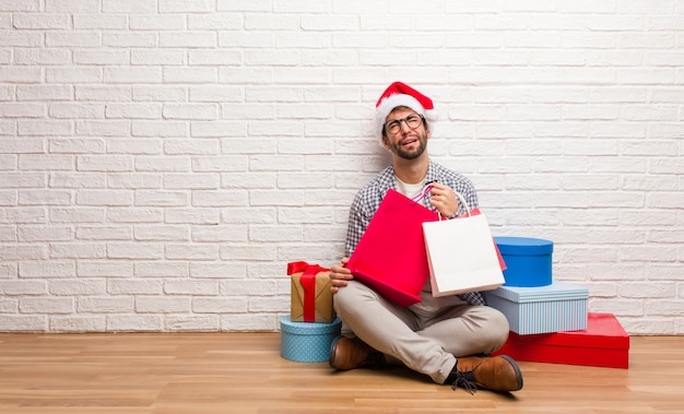 Junger verrückter Mann, der Weihnachten in seinem Haus feiert