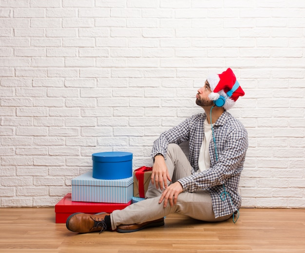 Junger verrückter Mann, der Weihnachten in seinem Haus feiert