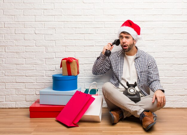 Junger verrückter Mann, der Weihnachten in seinem Haus feiert