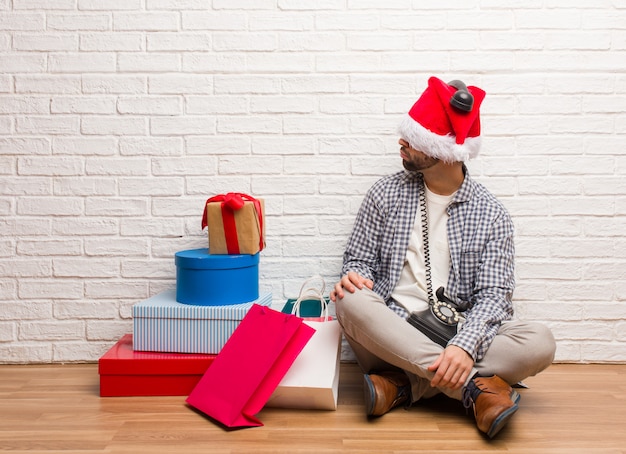 Junger verrückter Mann, der Weihnachten in seinem Haus feiert