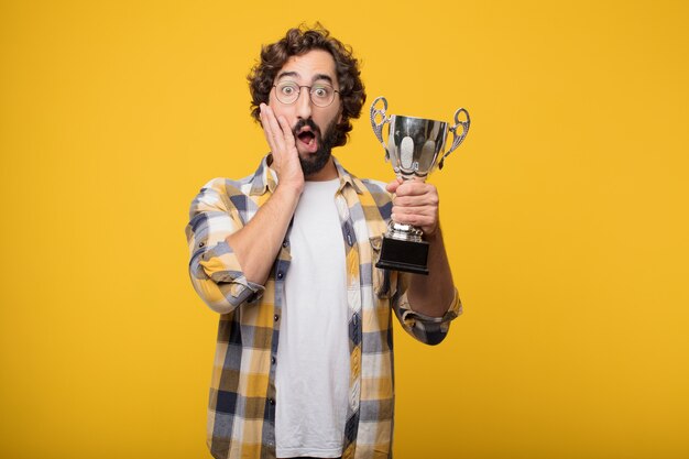 Foto junger verrückter verrückter manndummkopf werfen mit einer trophäe auf.