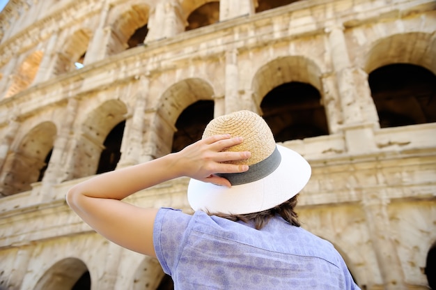 Junger weiblicher Reisender, der auf berühmtem das Colosseum in Rom schaut.