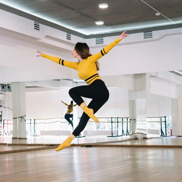 Foto junger weiblicher tänzer, der im tanzstudio übt