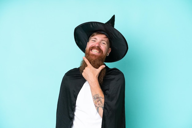 Junger Zauberer in Halloween isoliert auf blauem Hintergrund glücklich und lächelnd