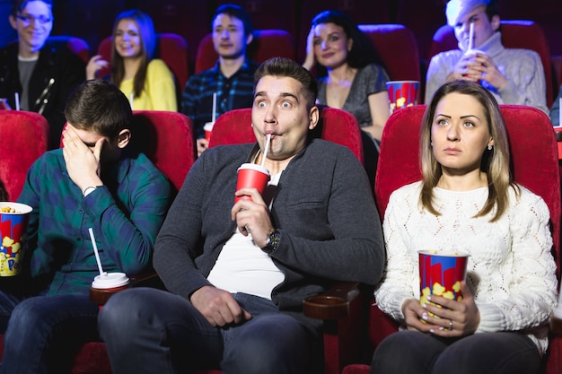 Junges ängstliches Paar im Kino, das einen Horrorfilm sieht