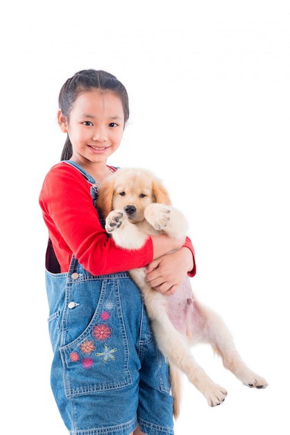 Junges asiatisches Mädchen, das ihren Hund und Lächeln über weißem Hintergrund hält