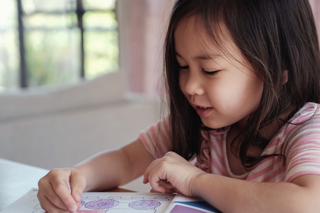 Junges asiatisches Mädchen, das zu Hause, homeschool Ausbildung zeichnet