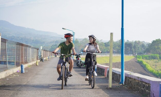 Junges asiatisches Paar fährt morgens zusammen Fahrrad