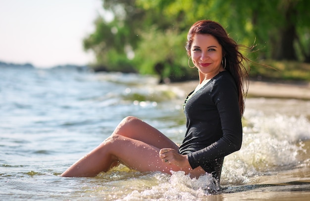 Junges attraktives Mädchen im Badeanzug am Strand