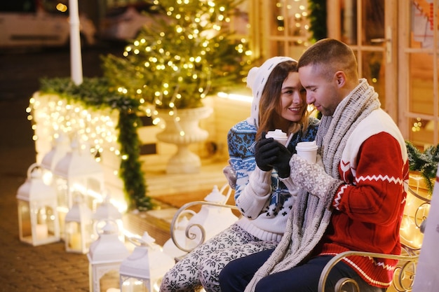 Junges attraktives Paar, das am Weihnachtstag in der Nähe des Weihnachtsbaums Zeit miteinander verbringt.