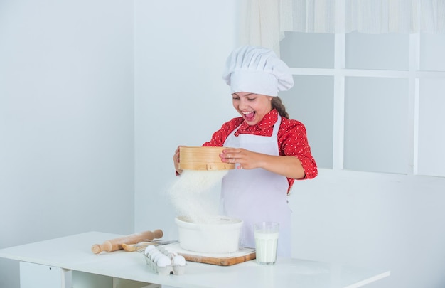 Junges Bäckerkind beim Kochuniformkochen