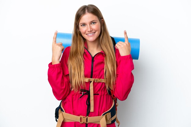 Junges Bergsteigermädchen mit großem Rucksack über isoliertem weißem Hintergrund, das auf eine großartige Idee zeigt