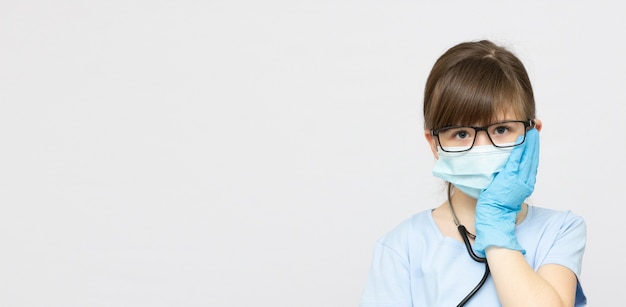 Junges blondes Mädchen mit Zahnschmerzen in medizinischem Maskenbanner-Kopienraum