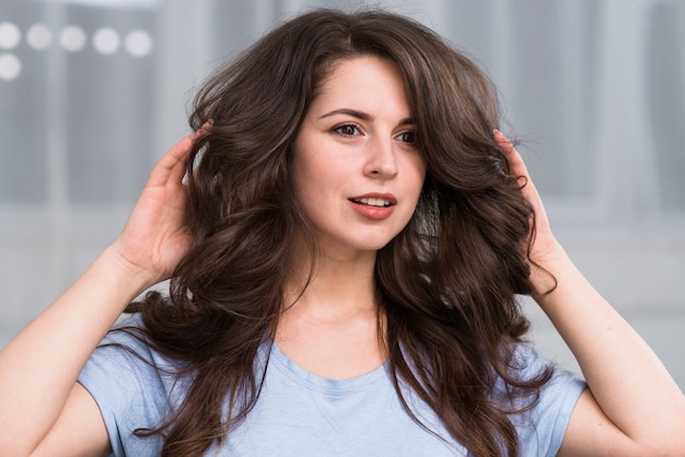 Junges Brunette, das gelocktes Haar einstellt