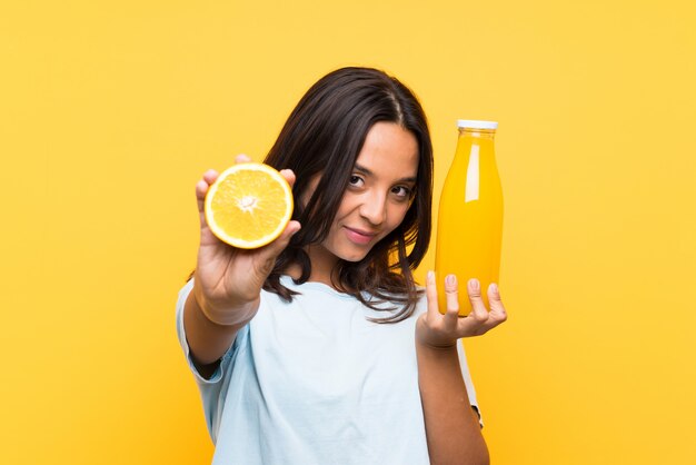 Junges Brunettemädchen, das eine Orange anhält