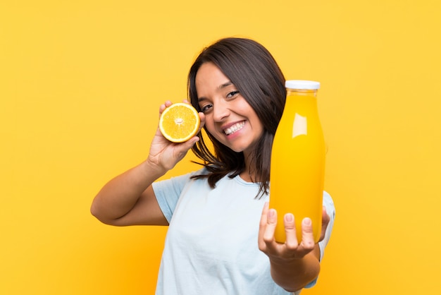 Junges Brunettemädchen, das eine Orange anhält