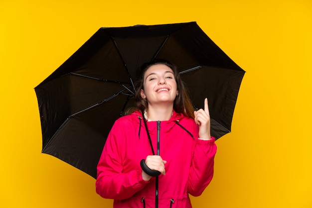 Junges Brunettemädchen, das einen Regenschirm oben zeigt eine großartige Idee hält
