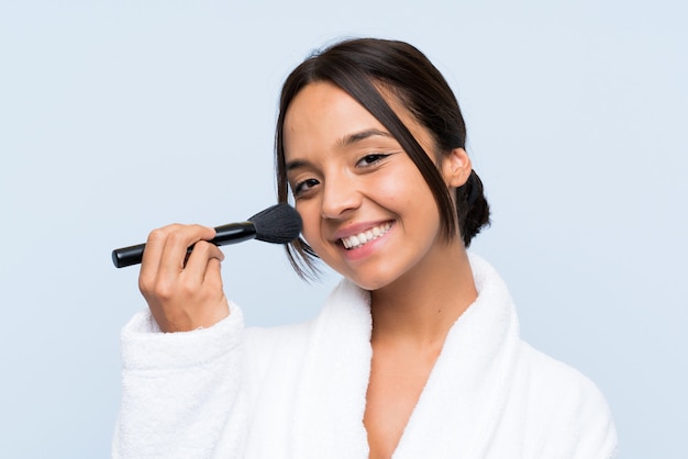 Junges Brunettemädchen im Bademantel mit Make-up