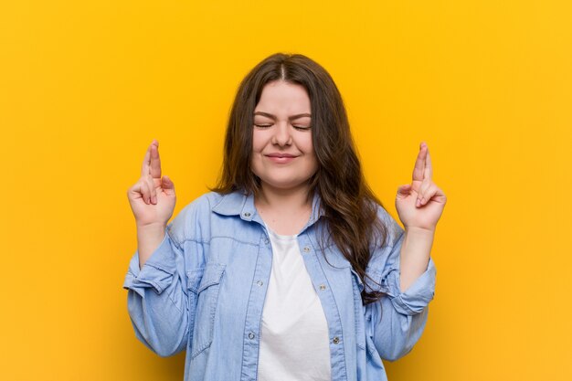 Junges curvy plus Größenfrauen-Überfahrtfinger für das Haben des Glücks