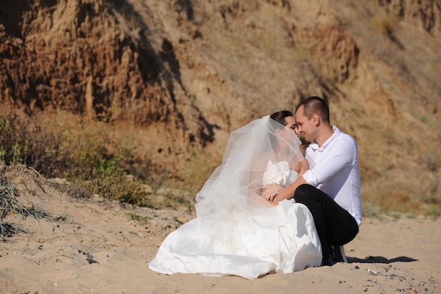 Junges erwachsenes Hochzeitsumarmungspaar-Foto im Freien